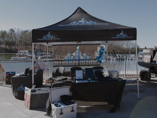 A Transcend Roofing Company tent is set up near a dock. A Transcend Roofing Company tent is set up near a dock.