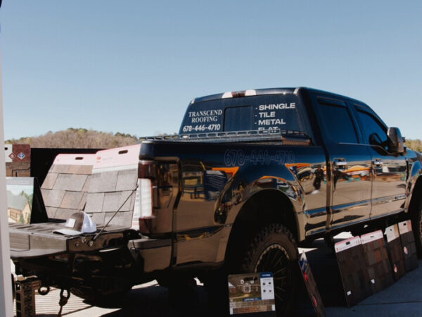 A black Transcend Roofing Company truck parked in a parking lot. A black Transcend Roofing Company truck parked in a parking lot.