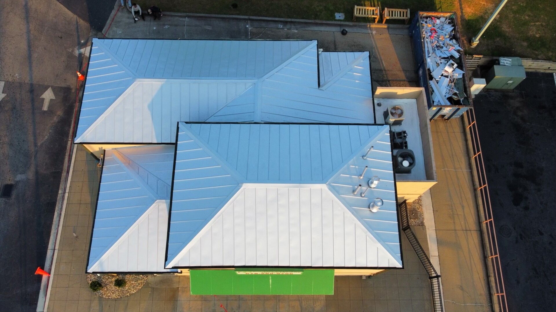 An aerial view of a building showcasing Transcend Roofing Company's metal roof.