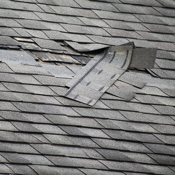 A badly damaged roof with missing shingles in need of repair