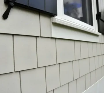 Contractor installing fiber cement siding on a home during a full exterior renovation