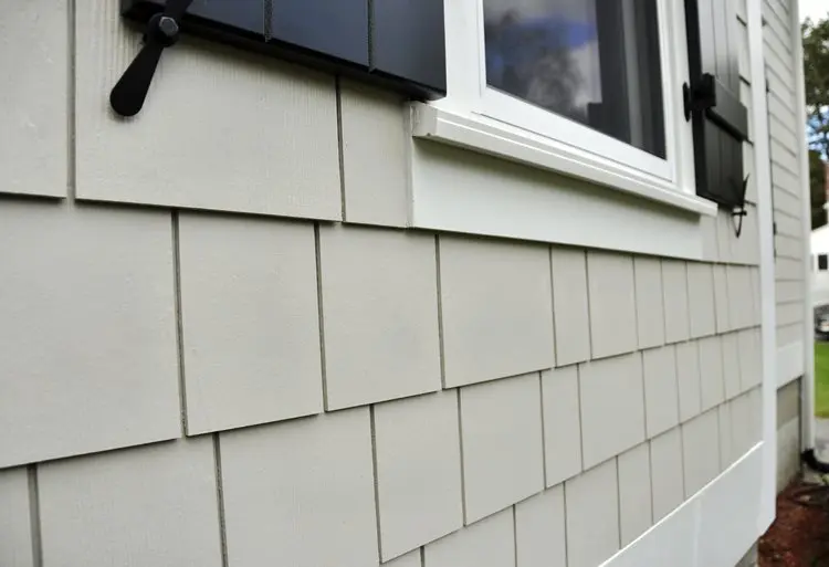 Contractor installing fiber cement siding on a home during a full exterior renovation